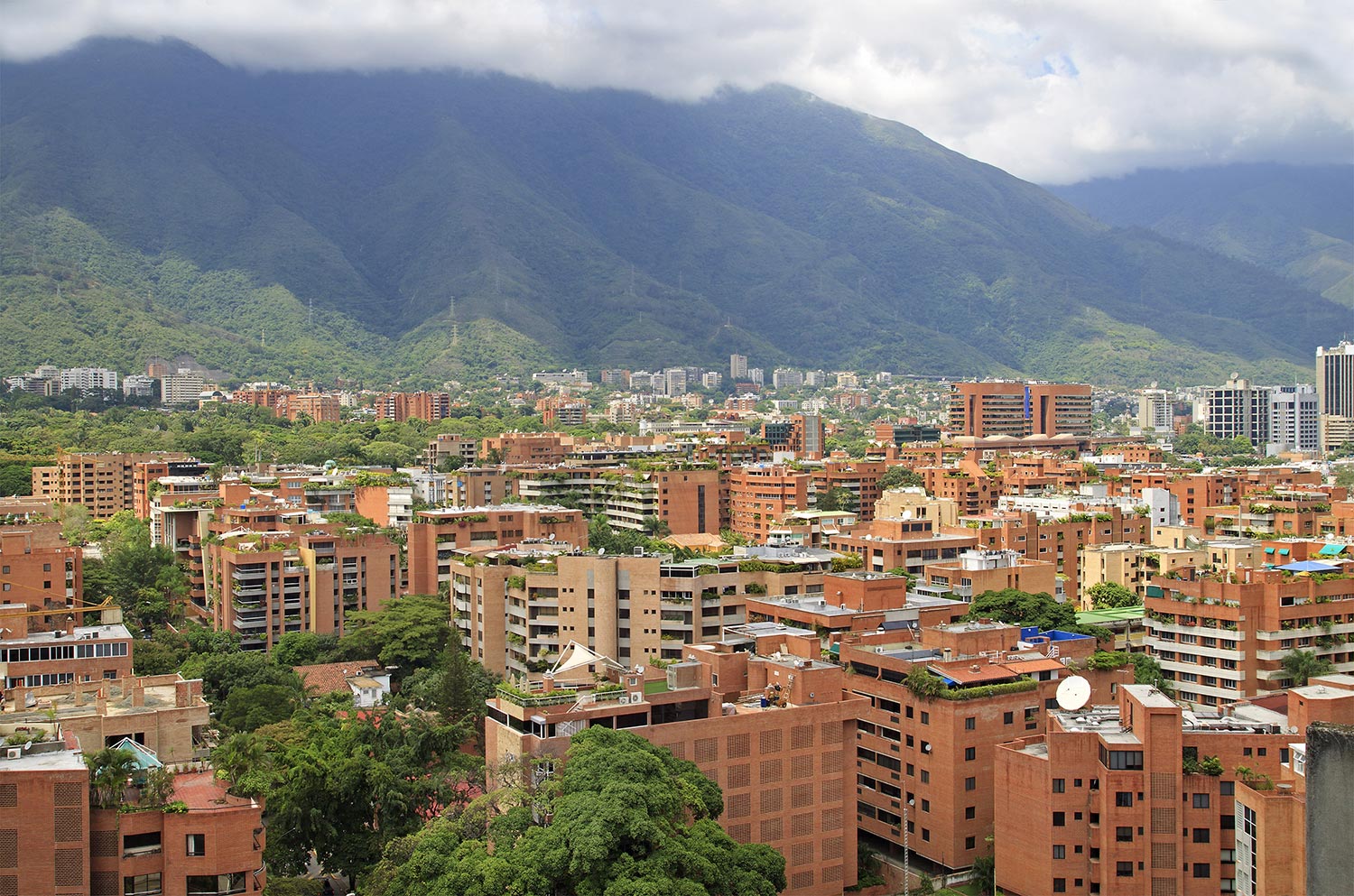 Aerial view of multi-level buildings in Caracas with mountains in the background