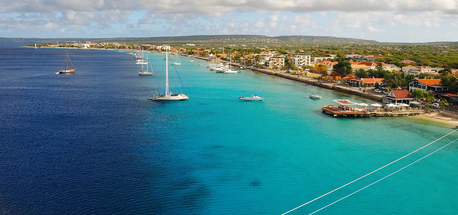 Small sailboats anchored in the multi-shade blue waters of Kralendijk