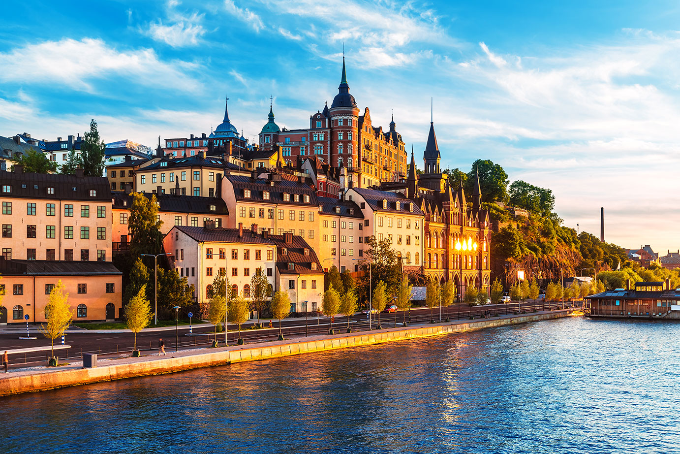 Colorful buildings line a canal in Stockholm at sunset